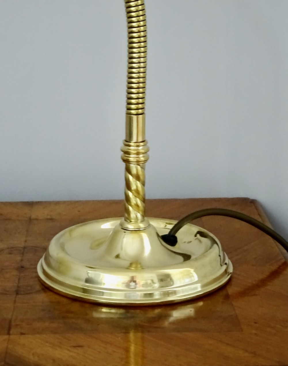 An Art Deco polished brass gooseneck desk lamp featuring an adjustable flexible arm, domed shade, and round stepped base. View II