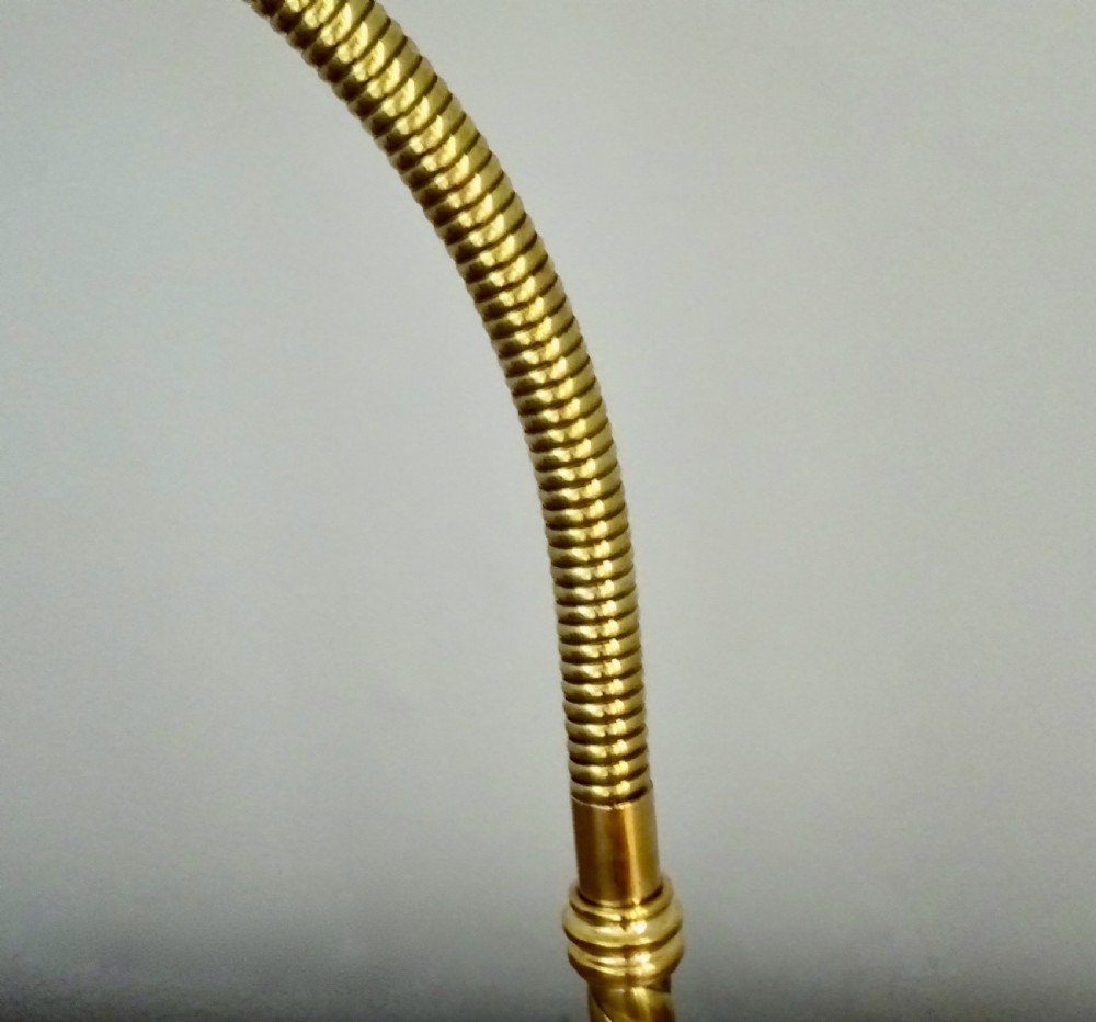 An Art Deco polished brass gooseneck desk lamp featuring an adjustable flexible arm, domed shade, and round stepped base. View IV