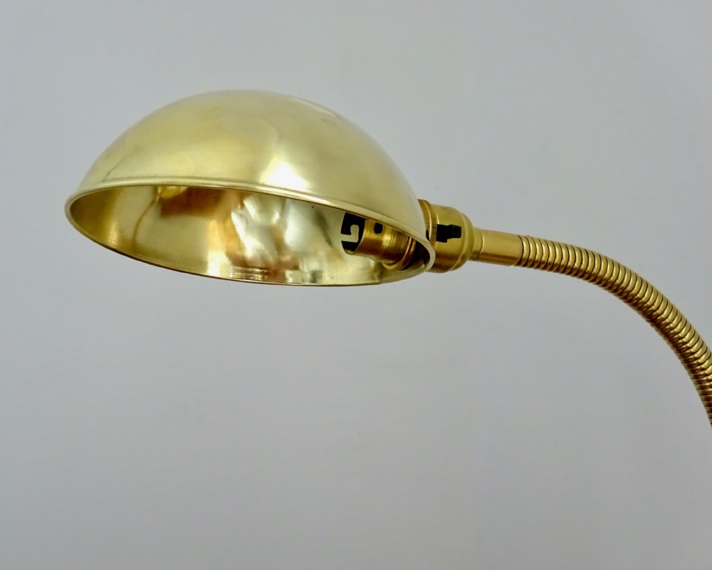 An Art Deco polished brass gooseneck desk lamp featuring an adjustable flexible arm, domed shade, and round stepped base. View III
