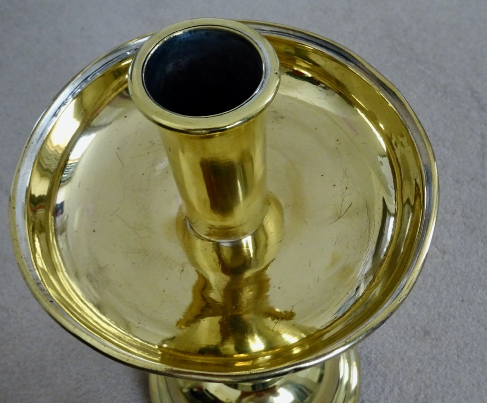 A pair of polished brass candlesticks with barley twist stems, broad drip pans, and domed bases set on small ball feet. View XI
