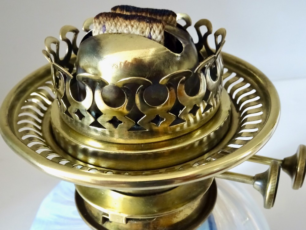 A Victorian brass wall-mounted oil lamp with a swirling blue glass reservoir held in a metal frame alongside a crimped blue glass shade. View XII