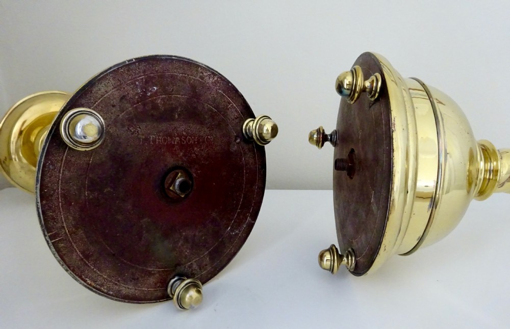 A pair of polished brass candlesticks with barley twist stems, broad drip pans, and domed bases set on small ball feet. View IX