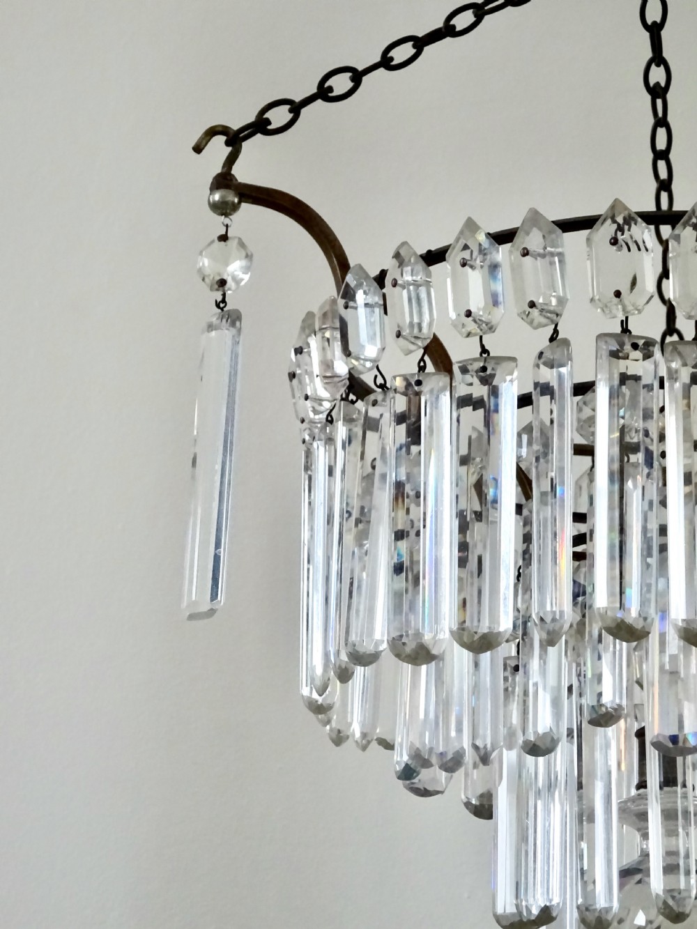 An Edwardian multi-tiered ceiling light featuring concentric rings of hanging cut crystal prisms suspended from a brass frame and chain. View IV