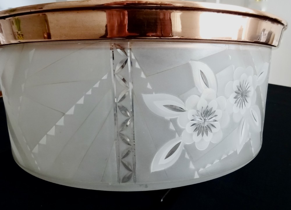 A circular 1930s flush mount ceiling light made of frosted glass featuring etched floral details and a polished copper gallery rim. View V