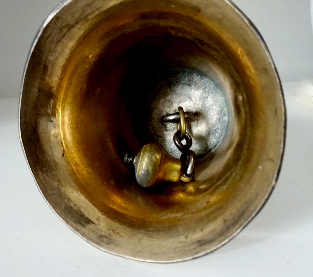 A polished brass hand bell featuring a flared skirt and a turned dark wooden handle. View VI