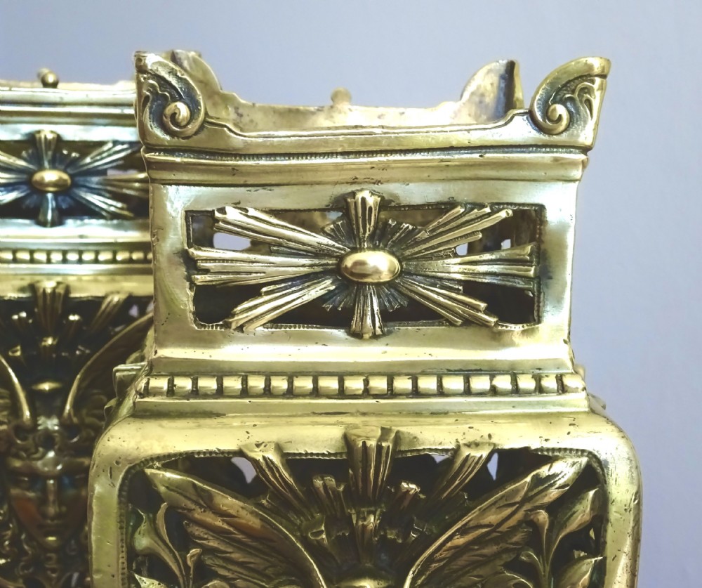 A pair of tall rectangular brass vases featuring pierced openwork scrolling foliage and central winged face motifs. View IV