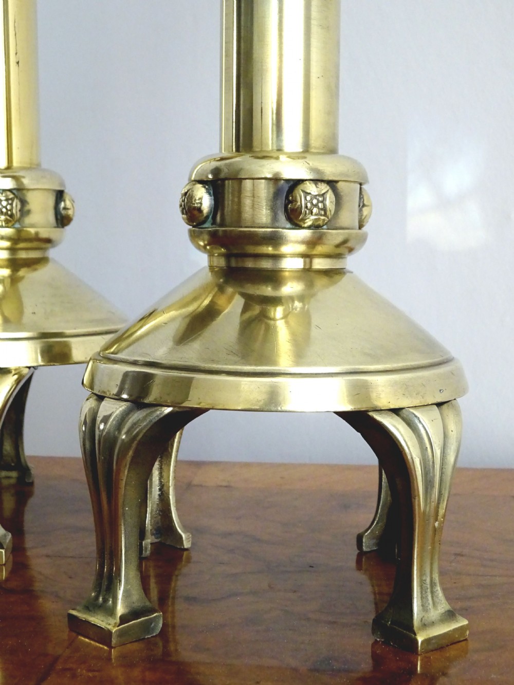 A pair of polished late Victorian brass pricket candlesticks featuring vertical spikes, flared drip pans, embossed stem knops, and tripod feet. View III