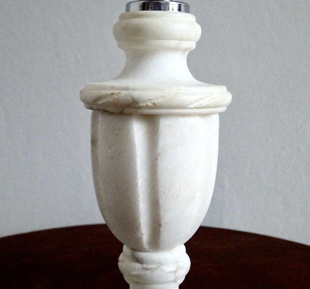 A small carved white marble table lamp base shaped like a classical urn resting on a square plinth. View III