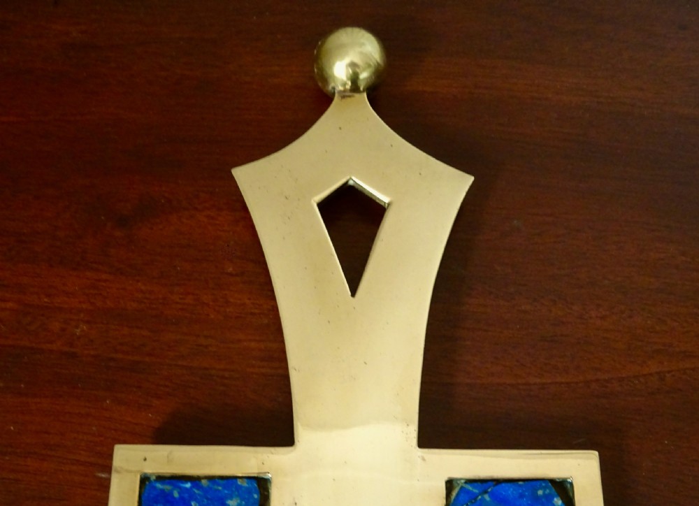 An Art Deco polished brass cross featuring flared arms with diamond cut-outs, ball finials, and four square lapis lazuli stone inlays at the centre. View III
