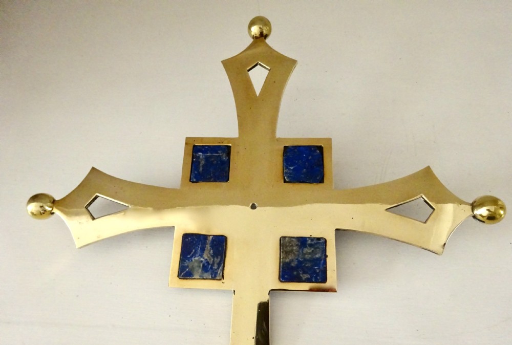 An Art Deco polished brass cross featuring flared arms with diamond cut-outs, ball finials, and four square lapis lazuli stone inlays at the centre. View IV
