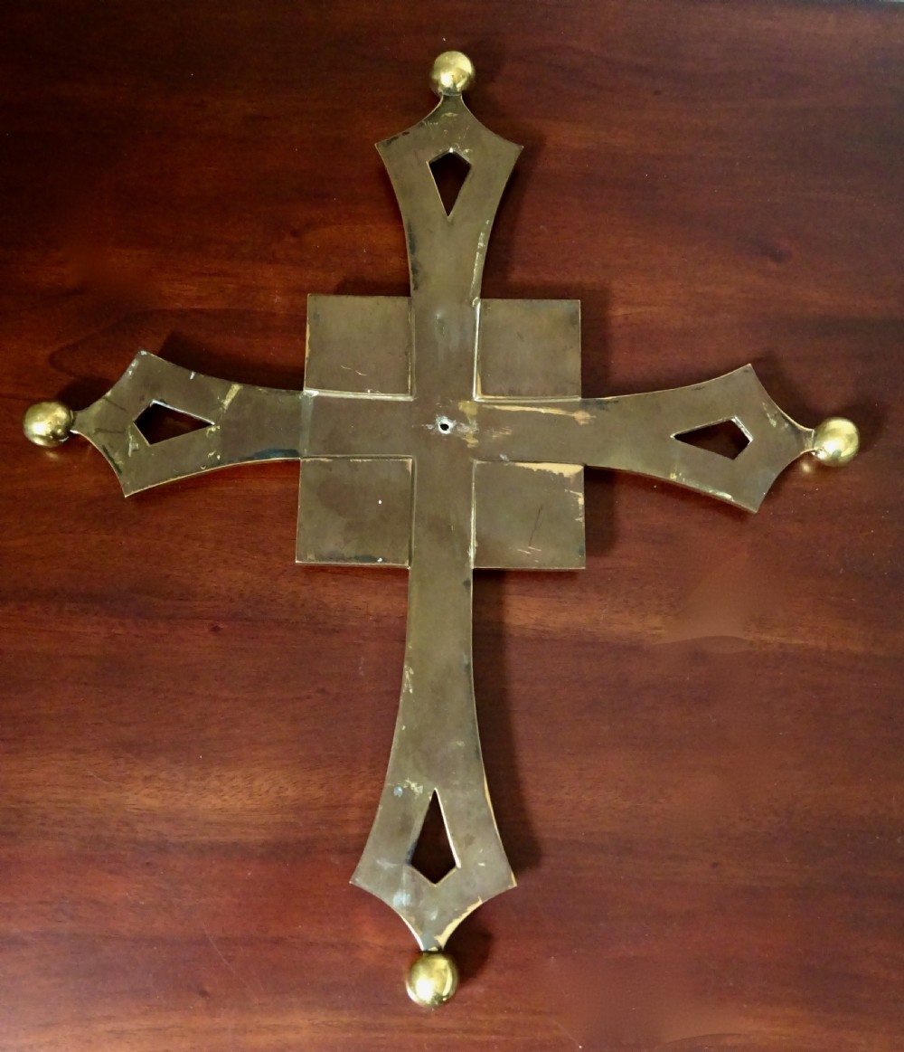 An Art Deco polished brass cross featuring flared arms with diamond cut-outs, ball finials, and four square lapis lazuli stone inlays at the centre. View VI