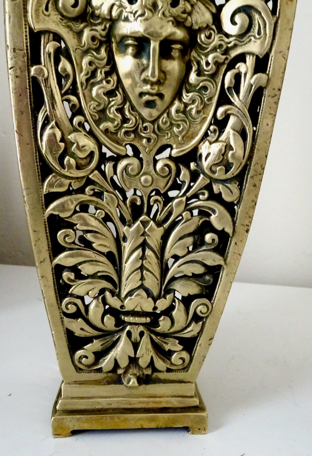 A pair of tall rectangular brass vases featuring pierced openwork scrolling foliage and central winged face motifs. View VII