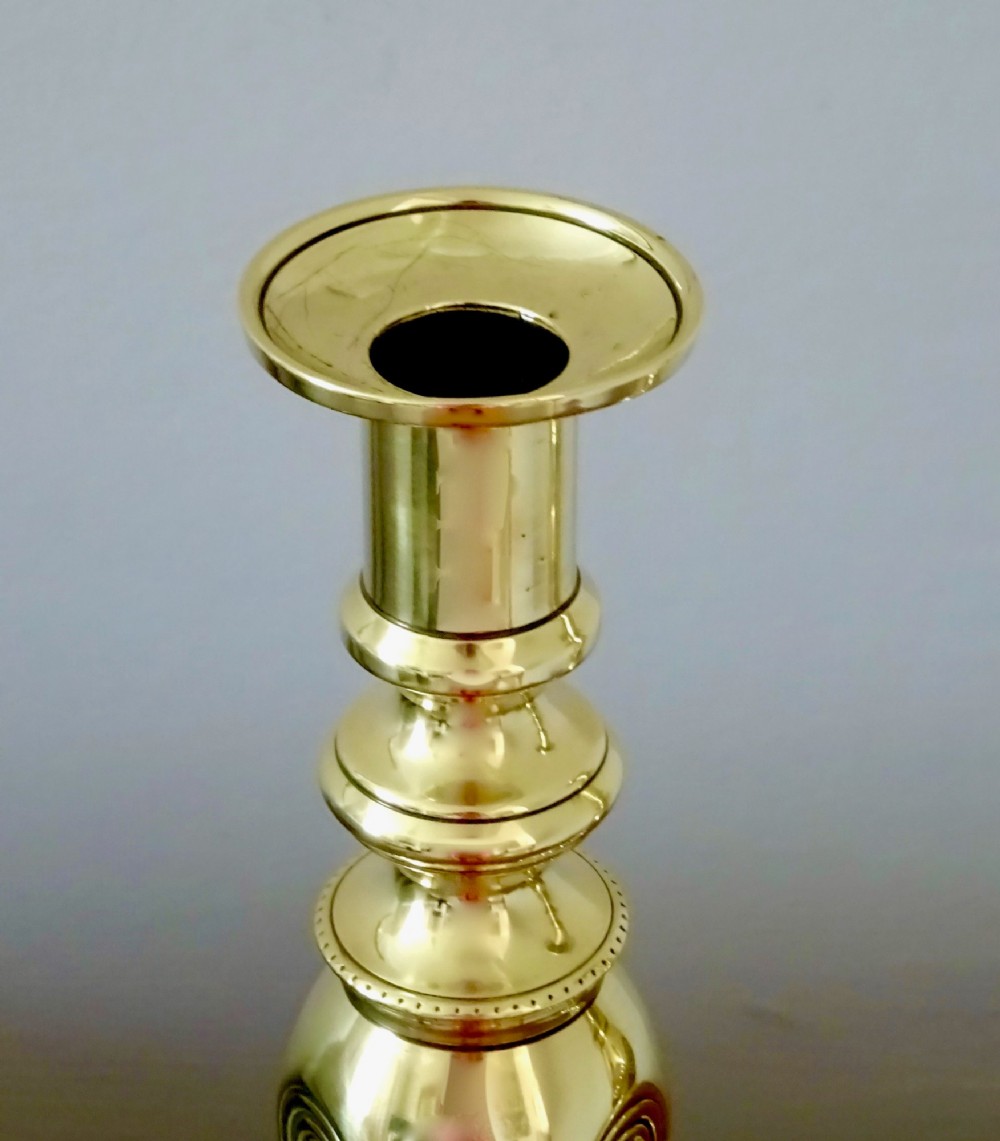 A pair of polished late Victorian cast brass candlesticks featuring knopped stems and octagonal bases stamped with the words Good Luck alongside a horseshoe motif. View III