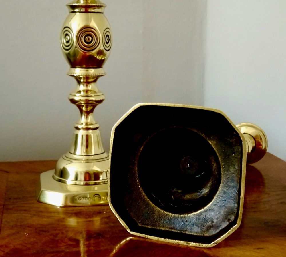 A pair of polished late Victorian cast brass candlesticks featuring knopped stems and octagonal bases stamped with the words Good Luck alongside a horseshoe motif. View IV