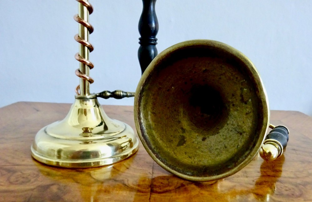 A pair of Edwardian Arts and Crafts brass candlesticks featuring spiral copper accents along the stems and turned dark wood side handles on circular brass bases. View VI