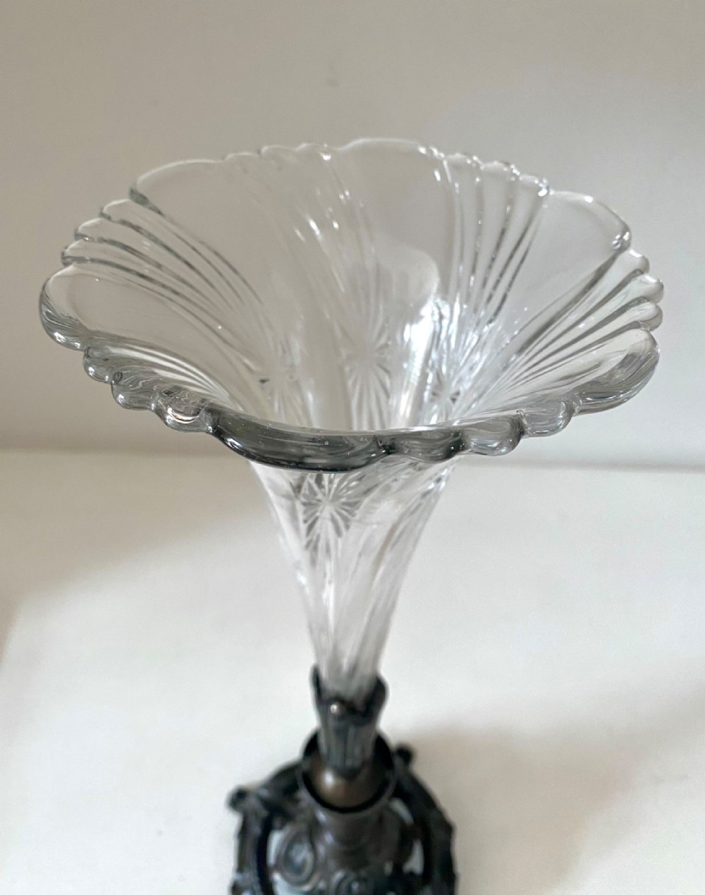 An antique single-trumpet epergne featuring a fluted clear glass vase fitted into an ornate dark cast-spelter base. View III