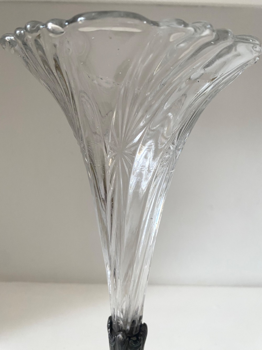 An antique single-trumpet epergne featuring a fluted clear glass vase fitted into an ornate dark cast-spelter base. View V