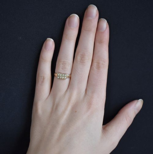 fig 1. A Victorian gold band ring featuring eight small cream seed pearls arranged in a rectangular panel set into the top.