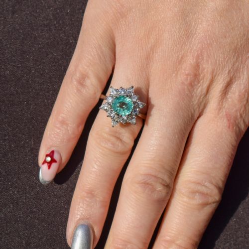 fig 1. A vintage gold cluster ring featuring a central octagonal green emerald surrounded by a snowflake halo of round and marquise diamonds.