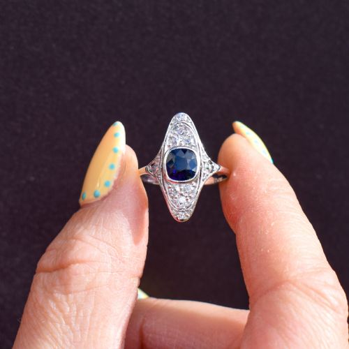 fig 2. An Art Deco platinum ring featuring a central blue sapphire framed by diamonds within an elongated navette-shaped setting.