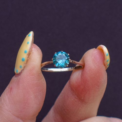 fig 1. A vintage 9ct gold solitaire ring featuring a brilliant round-cut blue zircon gemstone held in a multi-claw setting.