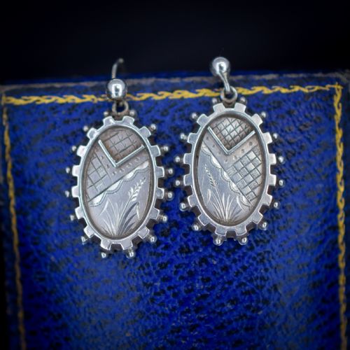 fig 2. A pair of oval sterling silver Victorian Aesthetic Movement drop earrings featuring engraved geometric and botanical designs with beaded borders.