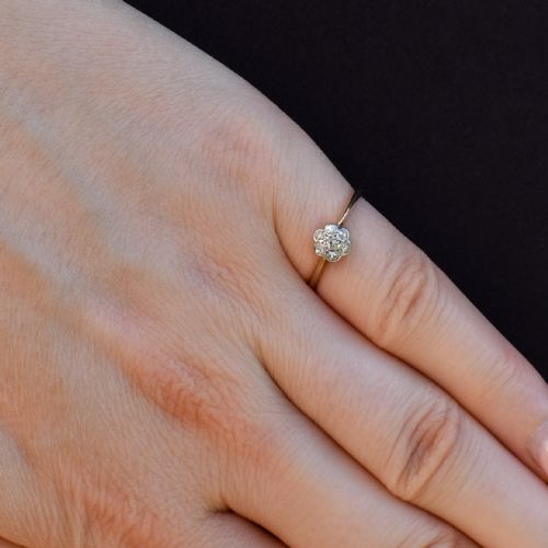 fig 1. An 18ct yellow gold ring featuring a floral diamond cluster head set in white metal.