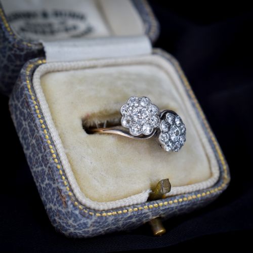 fig 2. An antique diamond ring featuring two circular daisy clusters on a crossover metal twist band.