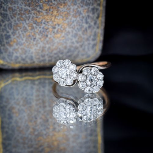 fig 3. An antique diamond ring featuring two circular daisy clusters on a crossover metal twist band.