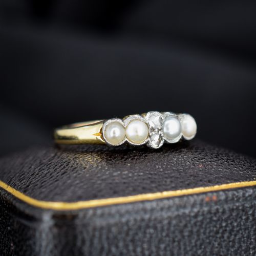 fig 1. An antique 18ct yellow gold ring set with four light cream pearls and two central rose-cut diamonds arranged horizontally.