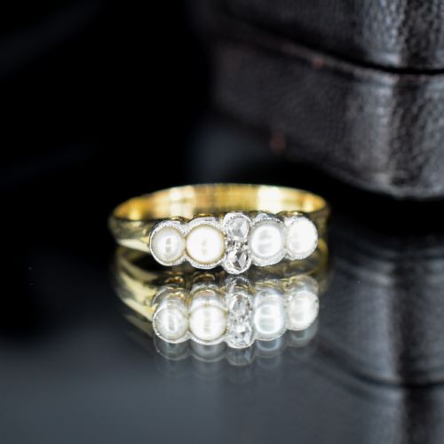 fig 2. An antique 18ct yellow gold ring set with four light cream pearls and two central rose-cut diamonds arranged horizontally.
