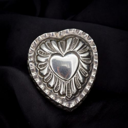 fig 1. An open heart-shaped sterling silver ring box featuring an embossed gilt interior lid and a green velvet base slot for a ring.