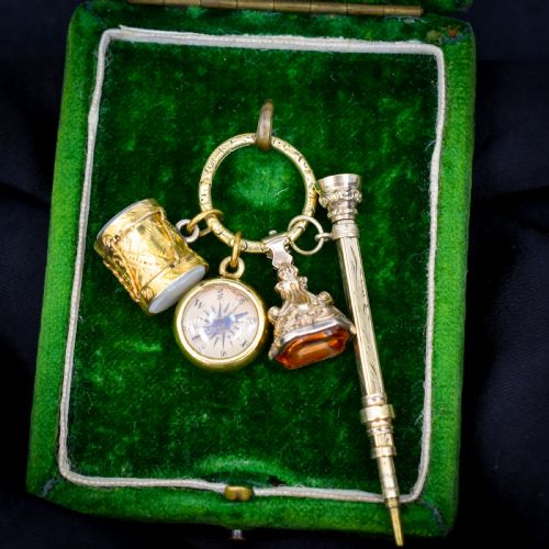 ANTIQUE CHARMS ON AN ENGRAVED SPLIT RING