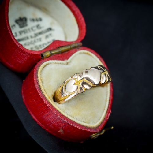 fig 2. An antique Victorian 9ct yellow gold band ring featuring polished heart motifs set against textured background detailing.