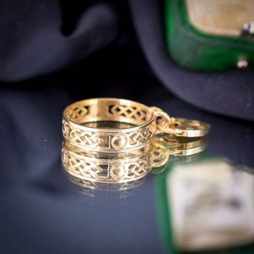 fig 2. A 9ct yellow gold band ring featuring an openwork Celtic knot design with a suspended heart-shaped padlock charm at the front.
