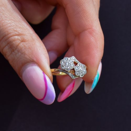 fig 1. An antique 18ct yellow gold ring with a double twist band featuring two diamond-set flower clusters.