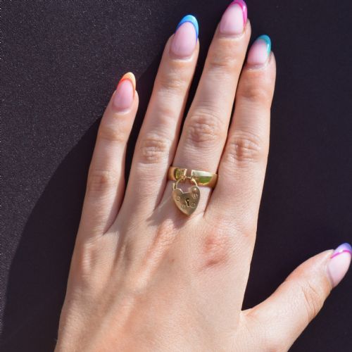 fig 2. An antique 9ct yellow gold band ring featuring a suspended heart-shaped padlock charm with keyhole and screw head details.