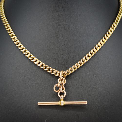 fig 1. A 9ct yellow gold uniform curb link Albert watch chain featuring a T-bar and dog clip fastings.