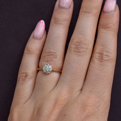 fig 2. An antique diamond daisy cluster ring set in platinum with an 18ct yellow gold band resting inside an open red heart-shaped velvet box.