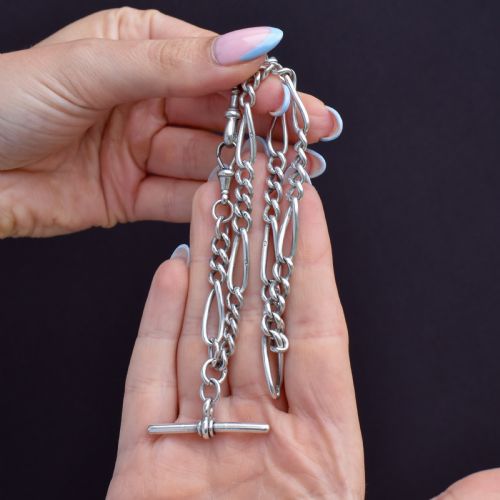 fig 1. An antique sterling silver double Albert watch chain featuring Figaro style links, a central T-bar, and dual swivel clasps.