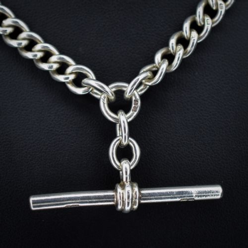 fig 2. An antique sterling silver heavy curb link Albert watch chain featuring a T-bar and swivel clasp, displayed flat.