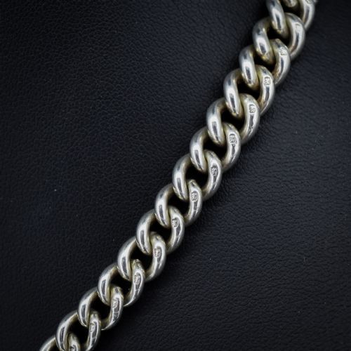 fig 3. An antique sterling silver heavy curb link Albert watch chain featuring a T-bar and swivel clasp, displayed flat.