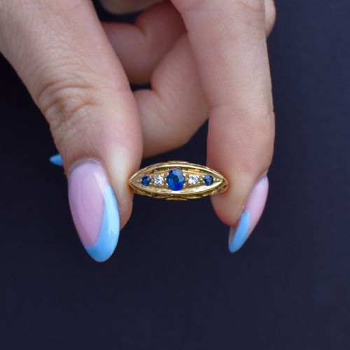 fig 1. An Edwardian 18ct yellow gold boat ring set with three blue sapphires and two diamonds in an elongated marquise-shaped mount.