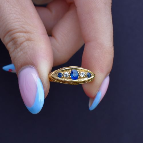 fig 2. An Edwardian 18ct yellow gold boat ring set with three blue sapphires and two diamonds in an elongated marquise-shaped mount.