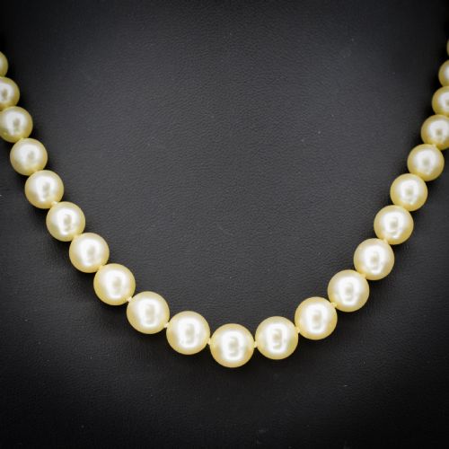 fig 2. A graduated strand of cream pearls featuring a yellow gold fluted clasp.
