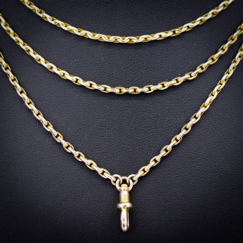 fig 2. A long 9ct yellow gold faceted link guard chain wrapped in loops beside a swivel dog clip clasp.
