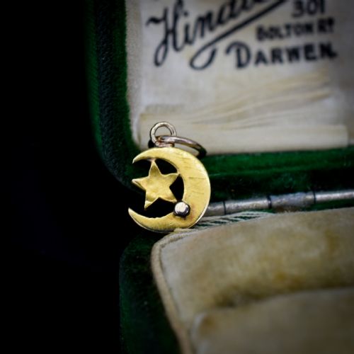 fig 2. An 18ct gold crescent moon pendant set with seed pearls enclosing a star motif.
