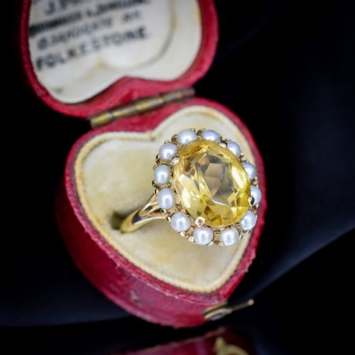 fig 1. A vintage 9ct gold ring featuring a central oval faceted yellow citrine gemstone surrounded by a halo of small white pearls.