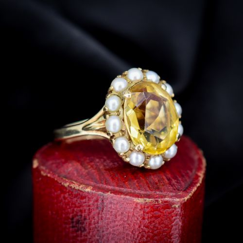 fig 2. A vintage 9ct gold ring featuring a central oval faceted yellow citrine gemstone surrounded by a halo of small white pearls.
