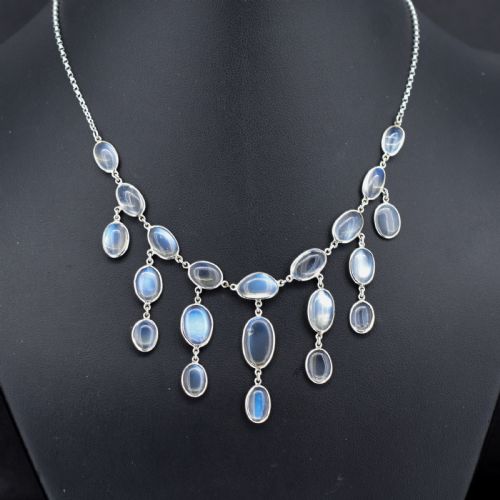 fig 1. An antique silver festoon necklace featuring tiered oval cabochon moonstone drops suspended from a central chain.